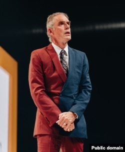 Jordan Peterson wears the "heaven and hell" suit designed by Dimitry Toukhcher. The hellish red half of the suit is woven from goat's wool, while the heavenly blue fabric is made of sheep's wool.