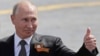 Russian President Vladimir Putin gestures to onlookers following a rescheduled Victory Day parade on Moscow's Red Square on June 24. 