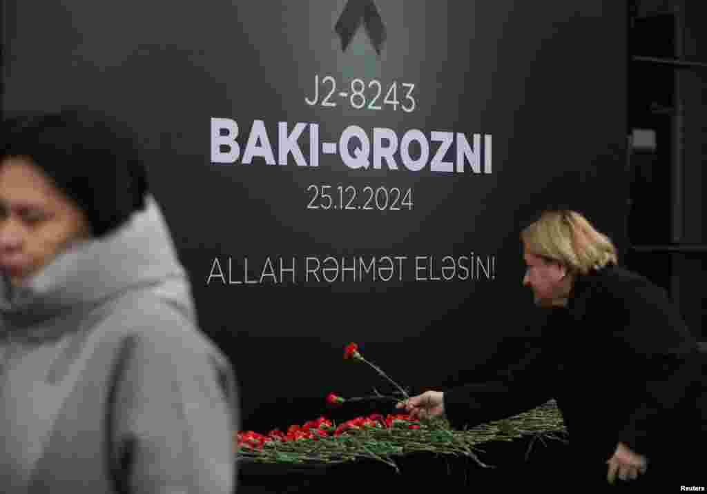 People lay flowers on December 26 in Baku to commemorate victims of the Azerbaijan Airlines flight that crashed in Kazakhstan the previous day.&nbsp;