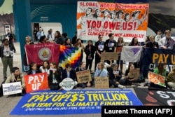 Activists hold a silent protest inside the COP29 venue to demand that rich countries provide climate finance to developing countries.