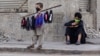 A young boy sells face masks on a stick in Karachi. 