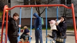 An employee wearing protective gear sprays disinfectant at a children's playground as a protective measure against the coronavirus in the western Ukrainian city of Lviv.