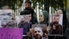 Demonstrators hold portraits of Zelimkhan Khangoshvili in front of the German Embassy in Tbilisi in September 2019.