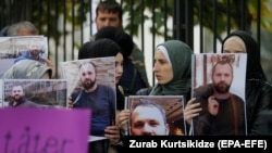 Demonstrators hold portraits of Zelimkhan Khangoshvili in front of the German Embassy in Tbilisi in September 2019.