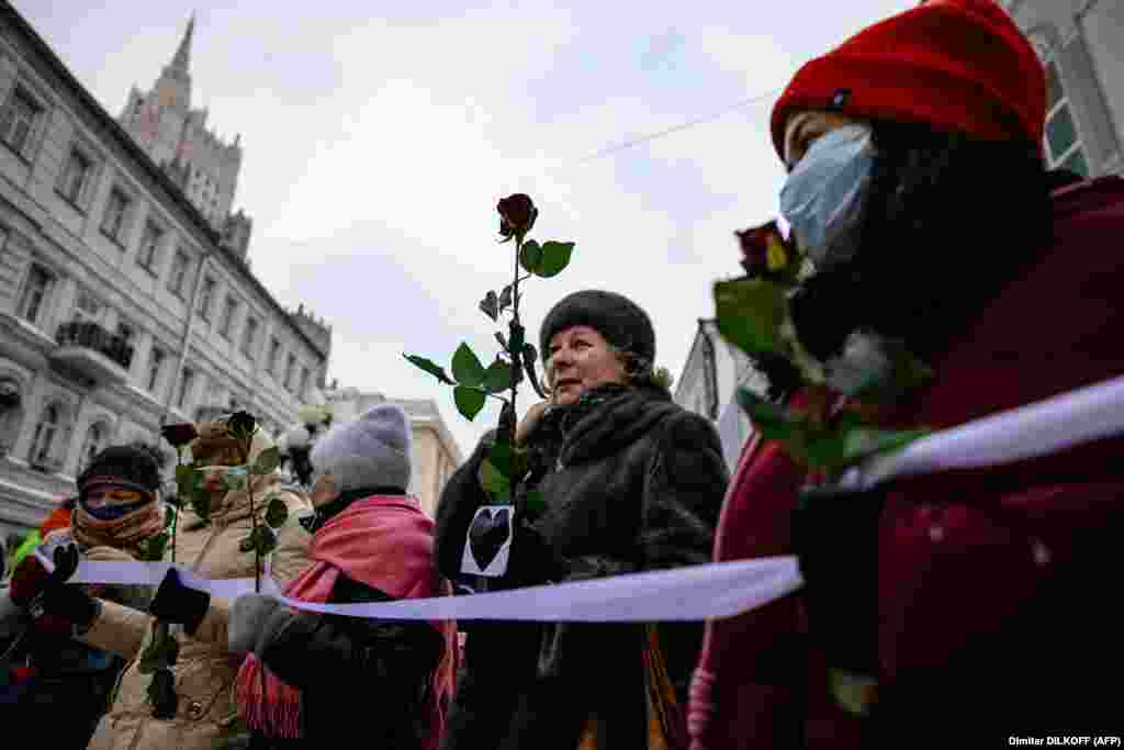 Russian women hold flowers as they form a human chain in Moscow to express support for Navalny on February 14.