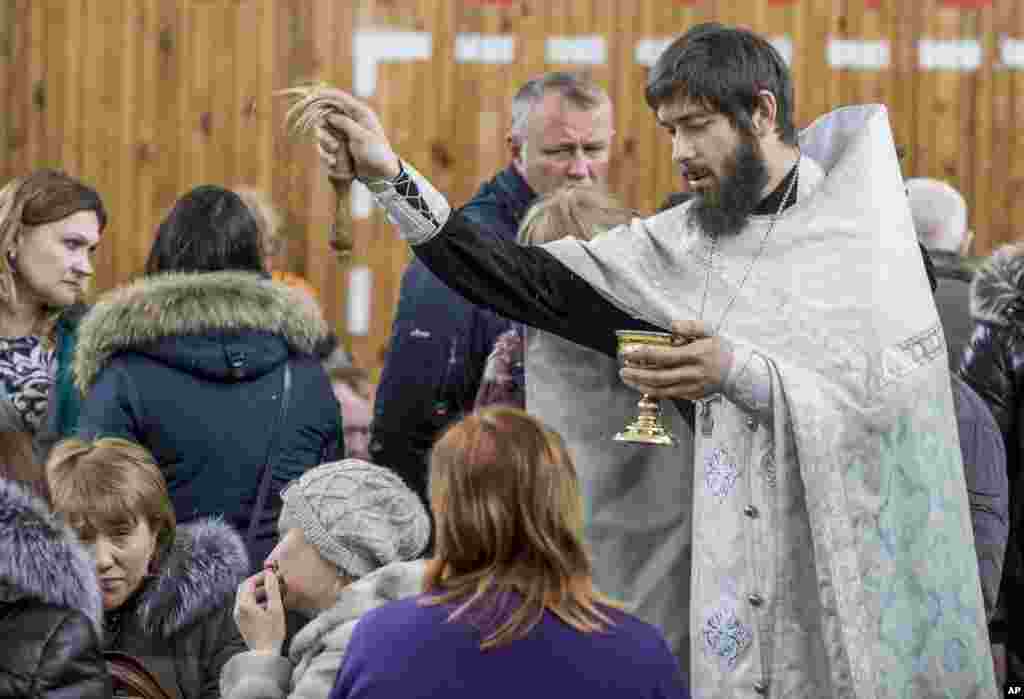 A Russian Orthodox priest conducts a requiem for the victims.