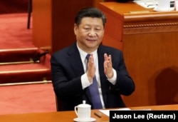 Chinese President Xi Jinping applauds after parliament passed a constitutional amendment lifting presidential term limits.