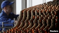 An employee works at a line bottling beer at a Carlsberg brewery in Krasnoyarsk. (file photo)