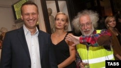 Aleksei Navalny (left) and his wife, Yulia, pose for a photo with Ekho Moskvy editor Aleksei Venediktov (right) in Moscow in 2015.