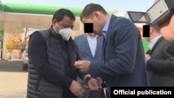 Raimbek Matraimov (left) is shown as he was detained in Bishkek on October 20.