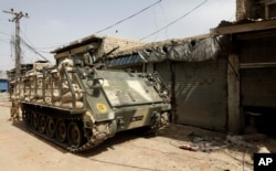 A Pakistani Army soldier stands atop an armored personnel carrier in the Miran Shah bazaar after driving out militants from North Waziristan in 2014.