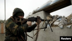 A militant fighting for Russia-backed separatist forces aims his weapon near the town of Avdiyivka, outside Donetsk,.