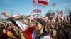 People wave old Belarusian republic flags during a rally commemorating the 1918 proclamation of independence from Russia in Minsk on March 25, 2018.