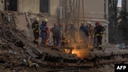 Rescuers clear rubble from the site of a missile attack on a children's hospital in Kyiv on July 8. 