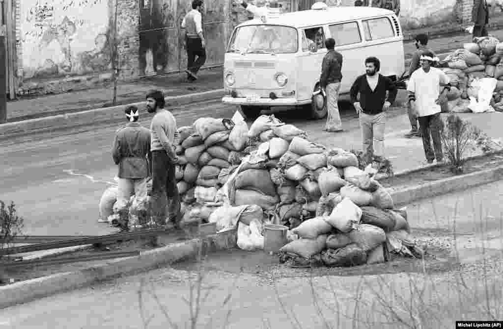 An ambulance passes sandbag roadblocks in Tehran to pick up the wounded from street clashes on February 10, 1979. A shootout between the army, air force cadets, and Khomeini followers left more than 60 people dead and hundreds injured.