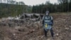 A pyrotechnician inspects the site after the blast at an ammunition depot near Vrbetice, Czech Republic, on October 20, 2014.