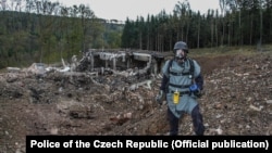 A pyrotechnician inspects the site after the blast at an ammunition depot near Vrbetice, Czech Republic, on October 20, 2014.