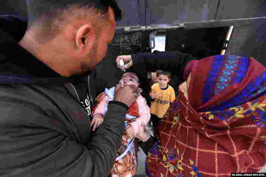 A health worker administers a polio vaccine to a child during a door-to-door vaccination campaign in Peshawar, Pakistan.&nbsp;