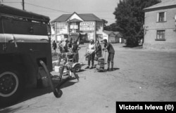 People wait in line for water at the fire station.