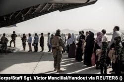 Evacuees wait to board a Boeing C-17 Globemaster III during an evacuation at Kabul Airport on August 30, 2021.