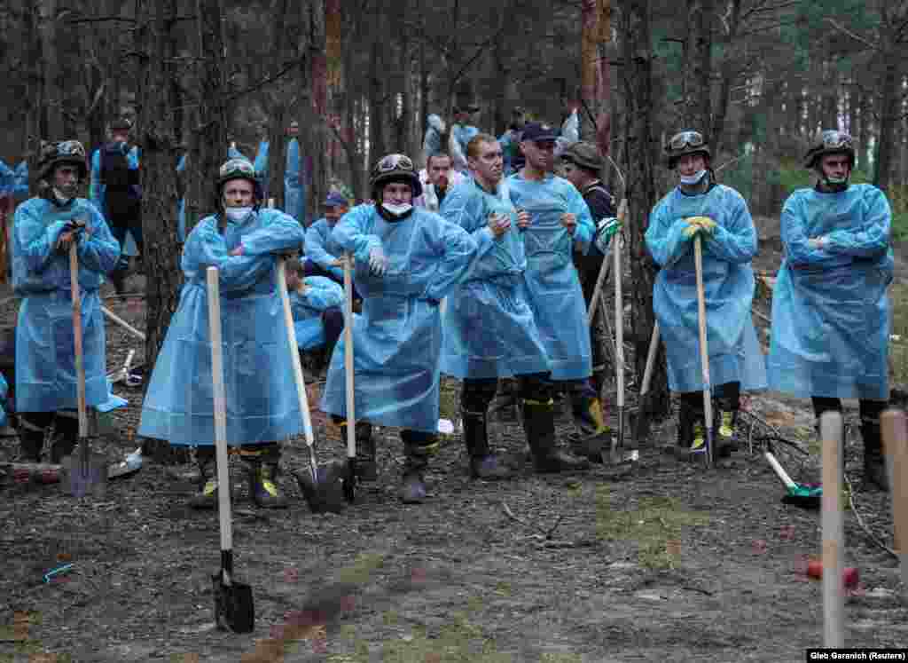 Members of Ukraine&rsquo;s Emergency Service rest during work to uncover a mass burial site in Izyum on September 16. After Izyum&rsquo;s recapture, several burial sites, including one containing the bodies of 440 people, were uncovered. &nbsp;