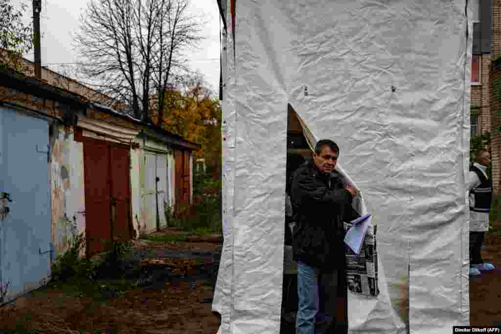 A man leaves a mobile DNA-testing laboratory in Izyum on November 4. DNA testing allows the identity of bodies to be confirmed without requiring relatives to go through the trauma of a visual identification. &nbsp;