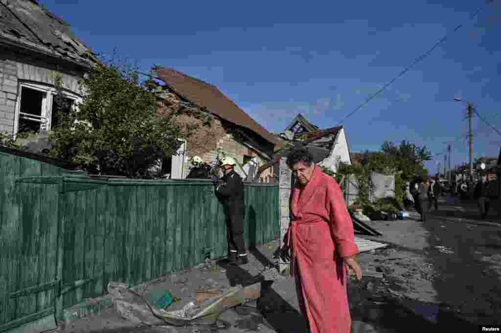 A woman stands next to her destroyed house in Zaporizhzhya.