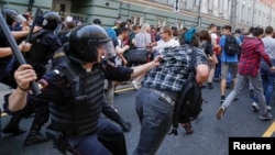 Police chase protesters during a rally against planned increases to the nationwide pension age in Moscow on September 9.