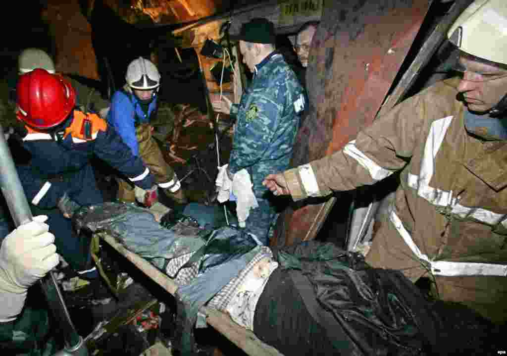 Rescuers carry a body from the metro car destroyed by the bomb blast.