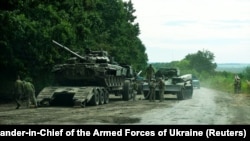 Ukrainian soldiers prepare to transport a Russian tank captured during a counteroffensive operation in the Kharkiv region on September 11.