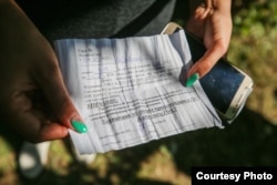 Yana shows the bill for the food given to her at Zhodzina jail.