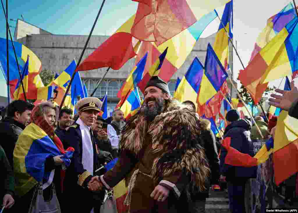 A man wearing an outfit inspired by Romania&#39;s Dacians ancestors walks near the Monument of the Heroes in Bucharest.