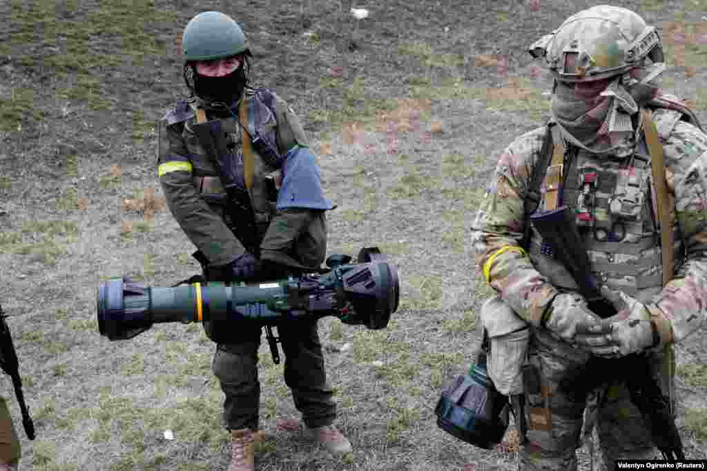 Members of the Ukrainian Territorial Defense Forces hold NLAW anti-tank weapons at a checkpoint in Kyiv on March 6.