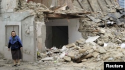 A woman stands near a demolished house in Baku last month.