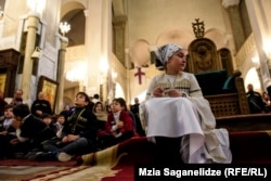 A girl sits inside the Holy Trinity Cathedral in Tbilisi, Georgia, during the Epiphany Mass on January 19. (Mzia Saganelidze, RFE/RL)