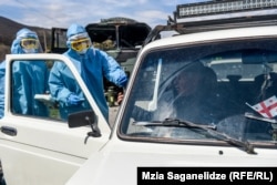 Georgian servicemen inspect cars and people approaching Tbilisi on March 31 after a nationwide lockdown went into effect. (Mzia Saganelidze, RFE/RL)