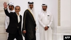 Iranian President Masud Pezeshkian (left) and Qatari Emir Sheikh Tamim bin Hamad al-Thani arrive at a joint press conference in Doha on October 2.