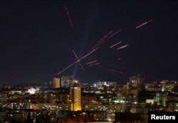 Tracers and searchlights are seen over Kyiv as Ukrainians fire at a drone during a Russian strike.