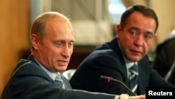 Mikhail Lesin (right), then Russia's press minister, listens as President Vladimir Putin speaks in 2002.