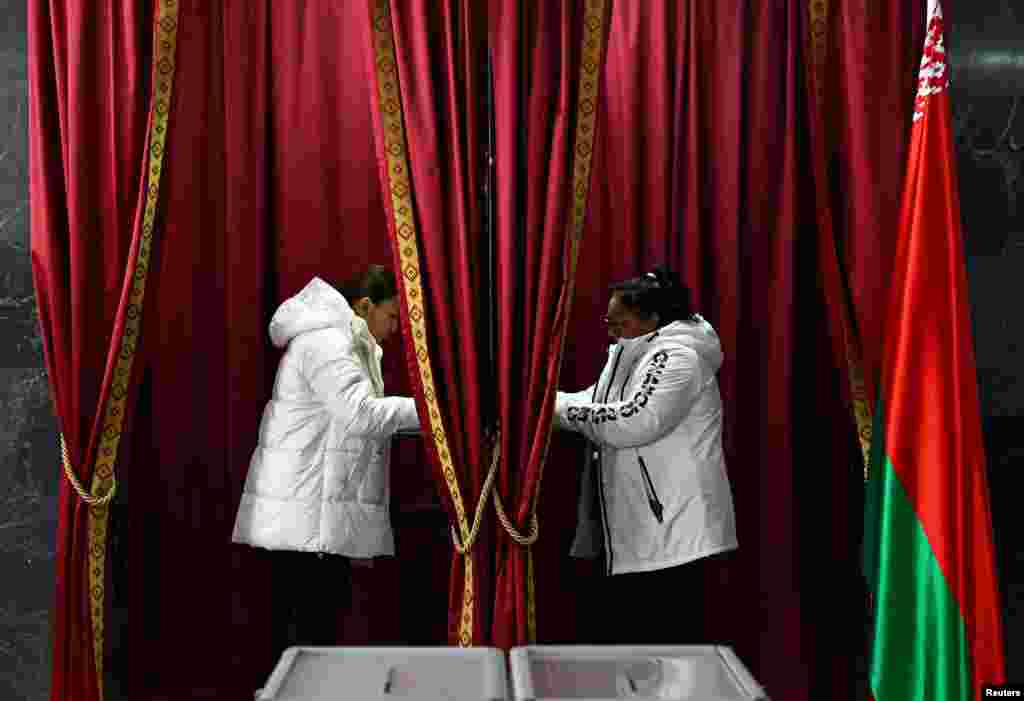 People stand in voting booths at a polling station during Belarus&#39;s presidential election in Minsk on January 26.