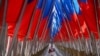 <p>A woman walks amid a display of Russian state flags installed on a square in central Moscow on February 24, the third anniversary of Russia's full-scale invasion of Ukraine. 