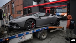 A police officer looks on as a luxury vehicle in the case against media influencer Andrew Tate is towed away on the outskirts of Bucharest on January 14.