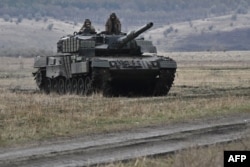 Ukrainian troops ride a German-made Leopard tank at an undisclosed location in Ukraine in October 2024.