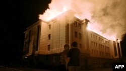 Bystanders watch a fire consuming a school in the eastern Ukrainian city of Donetsk on August 27.