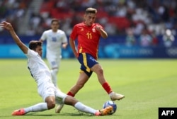 Khusanov, seen here tackling Fermin Lopez in Uzbekistan's game with Spain at the 2024 Olympics, is believed to be one of the fastest players in the world in his position. (file photo)