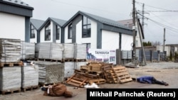 The bodies of two people in civilian clothes lie on a street in Bucha on April 3. They were shot by Russian soldiers, according to local residents. The hands of one of the bodies are tied behind its back.