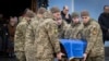 Soldiers carry a coffin of Ukrainian soldier Andriy Kuzmenko, who was killed in the Russia-Ukraine war, during a farewell ceremony at the St. Michael's Monastery in Kyiv on January 10.