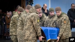 Soldiers carry a coffin of Ukrainian soldier Andriy Kuzmenko, who was killed in the Russia-Ukraine war, during a farewell ceremony at the St. Michael's Monastery in Kyiv on January 10.