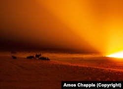 Goats gather near the crater as it burns through the night.