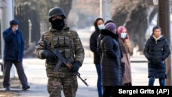 A Kazakh soldier patrols an Almaty street following deadly protests that rocked the city at the start of the year. 